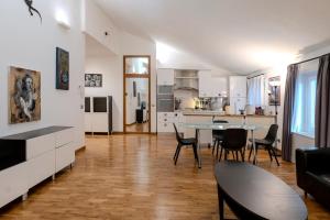 a kitchen and a living room with a table and chairs at Restart Accommodations Dea Roma in Rome