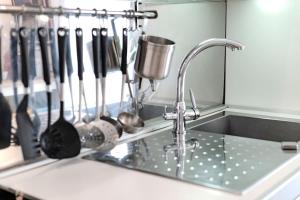 a kitchen sink with utensils on a wall and a kitchen sink at Restart Accommodations Dea Roma in Rome +86 photos