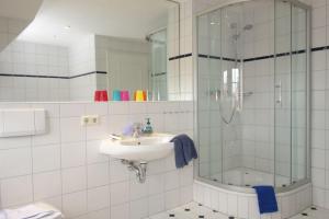 une salle de bain avec lavabo et douche dans l'établissement Ferienhaus Adebar 1, à Oevenum 16 autres photos