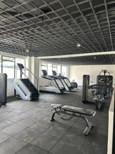 a gym with several treadmills and machines in it at A cozy studio apartment in Ruaka