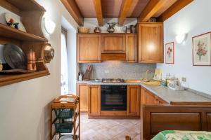 a kitchen with wooden cabinets and a stove top oven at La casa di Sophia - vicino alle piste da sci in Ponte di Legno +10 photos