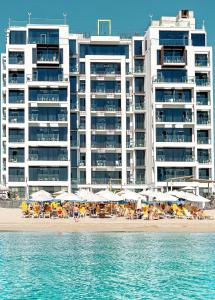 a large building on the beach with chairs and umbrellas at C Central Hotel and Resort The Palm in Dubai
