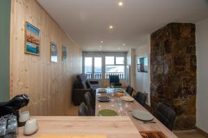 a dining room with a table and a stone wall at La Ludette - Pied des pistes à Pla dAdet in Saint-Lary-Soulan