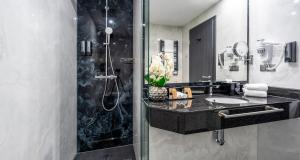a bathroom with a sink and a shower with a mirror at PLAZA Premium Schwerin Sure Hotel Collection by Best Western in Schwerin +113 photos