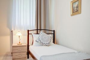 a small bedroom with a bed and a nightstand and a bed sidx sidx sidx at Azure Bay Villa by RentalsPro - Neos Marmaras Halkidiki in Paradisos