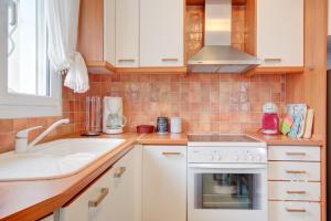 a kitchen with a sink and a stove at Azure Bay Villa by RentalsPro - Neos Marmaras Halkidiki in Paradisos