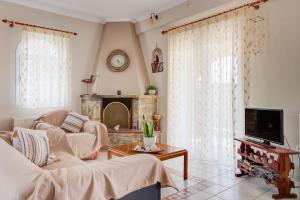a living room with two couches and a tv at Azure Bay Villa by RentalsPro - Neos Marmaras Halkidiki in Paradisos