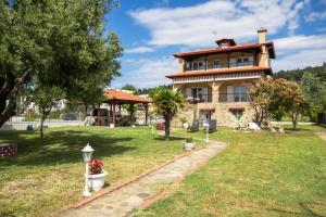 a large house with a garden and a grass yard at Azure Bay Villa by RentalsPro - Neos Marmaras Halkidiki in Paradisos