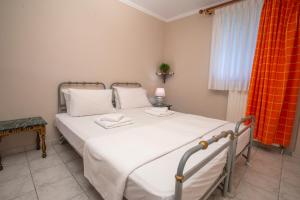 a bedroom with a white bed with a red curtain at Azure Bay Villa by RentalsPro - Neos Marmaras Halkidiki in Paradisos