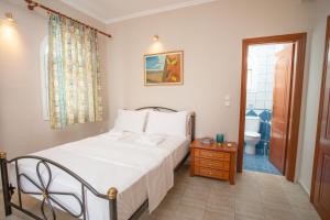 a bedroom with a bed and a bathroom at Azure Bay Villa by RentalsPro - Neos Marmaras Halkidiki in Paradisos