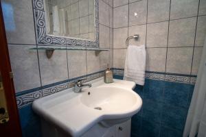 a bathroom with a white sink and a mirror at Azure Bay Villa by RentalsPro - Neos Marmaras Halkidiki in Paradisos