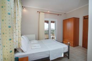 a bedroom with a white bed and a window at Azure Bay Villa by RentalsPro - Neos Marmaras Halkidiki in Paradisos