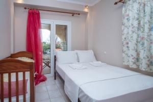 a bedroom with a bed and a crib and a window at Azure Bay Villa by RentalsPro - Neos Marmaras Halkidiki in Paradisos