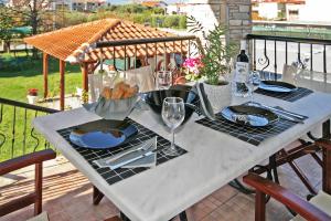 a white table with plates of food on top of a balcony at Azure Bay Villa by RentalsPro - Neos Marmaras Halkidiki in Paradisos