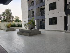 a building with a courtyard with two potted plants at A cozy studio apartment in Ruaka