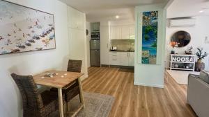 a living room and kitchen with a table and chairs at Noosa Bliss - Self Contained, Pool, Tennis, Gym in Noosa Heads +24 photos