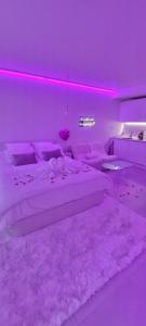 una camera da letto con letto e illuminazione viola di Love room à 30 mn des plages et de Vannes a Questembert