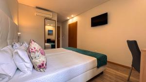 a bedroom with a bed and a television on the wall at Sea Garden Peniche in Peniche
