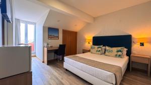 a hotel room with a bed and a desk at Sea Garden Peniche in Peniche
