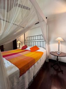 a bedroom with two beds and a table at The Garden House Galle - Garden View Room in Galle