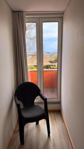 a black chair sitting in front of a window at Sea Garden Peniche in Peniche