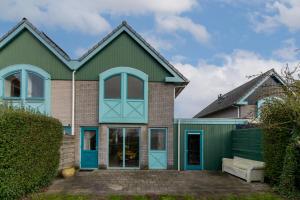ein Haus mit blauen und grünen Türen in der Unterkunft Grasse 150 - Kustpark Village Scaldia in Hoofdplaat