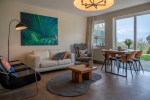 ein Wohnzimmer mit Sofa und Tisch in der Unterkunft Grasse 150 - Kustpark Village Scaldia in Hoofdplaat