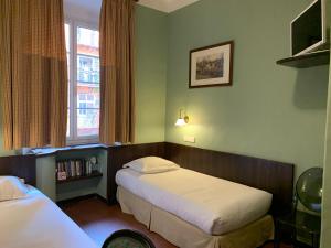 Una habitación de hotel con dos camas y una ventana. en Hotel Central Bastia, en Bastia 105 fotos más