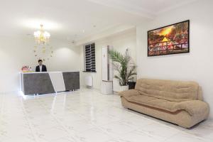 Hostel 1001 Noch في طشقند: رجل يقف في غرفة المعيشة مع أريكة