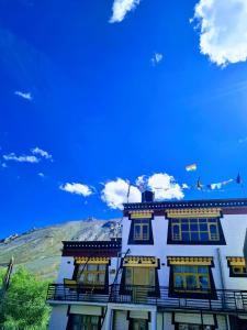 a building with flags on top of it with a mountain at Pema's Cottage Chicham Kaza in Kaza