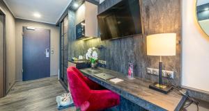 a room with a desk and a red chair at PLAZA Premium Schwerin Sure Hotel Collection by Best Western in Schwerin