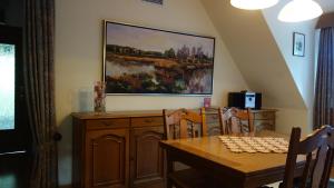 a dining room with a table and a painting on the wall at Ferienwohnung Kiefernblick-Wedemann in Bispingen