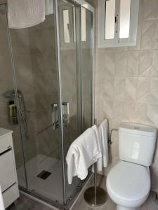 ein Badezimmer mit Toilette und Dusche mit Handtüchern in der Unterkunft Piso céntrico en Conil de la Frontera in Conil de la Frontera