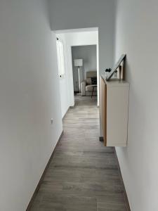 ein Flur mit weißen Wänden und einem Boden mit Holzböden in der Unterkunft Piso céntrico en Conil de la Frontera in Conil de la Frontera