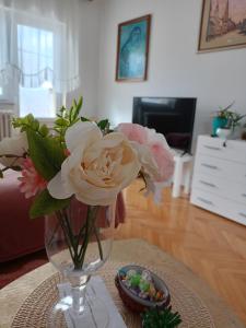 eine Vase mit Blumen auf einem Tisch im Wohnzimmer in der Unterkunft Kleopa in Pale