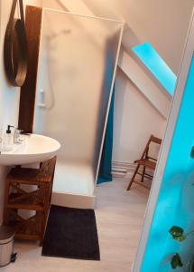 a bathroom with a sink and a bath tub at La Maison des Ifs Paon in Mamers