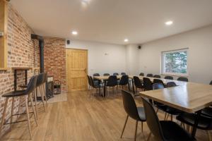 a room with tables and chairs and a brick wall at Chalet Fridrihštajn in Kočevje