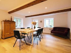 een eetkamer met een houten tafel en stoelen bij Reethus Koppelkiek in Husby