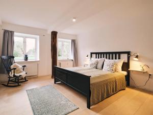 een slaapkamer met een bed, een stoel en een raam bij Reethus Koppelkiek in Husby +34 foto's