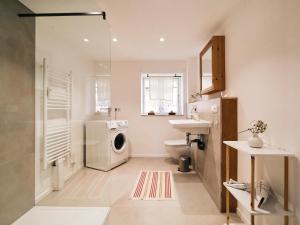 a bathroom with a washing machine and a sink at Reethus Koppelkiek - stilvolles Vintage-Haus mit Spielhaus & großem Außenbereich in Husby +31 photos