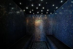a dark room with benches and lights on a wall at M&V Resort Camping in Langrune-sur-Mer