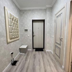 an empty hallway with a door and a table at Момышулы 28-433 уютно стильно in Fëdorovka +2 photos