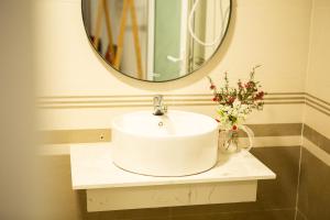 un bagno con un lavandino bianco e uno specchio di Lahill I Cozy Home I Best View a Xuan An Altre 54 foto