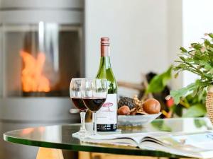 une bouteille de vin et un verre sur une table dans l'établissement NEW Squirrels Leap Lake Views with Spa Access, à Somerford Keynes 25 autres photos