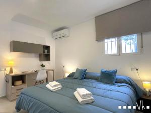a bedroom with a blue bed and a desk at VH CostaBlanca - MORAVIT in Moraira