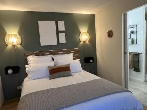 a bedroom with a large bed with two lamps at Les Arches du Lac in Saint-Martin-lès-Langres