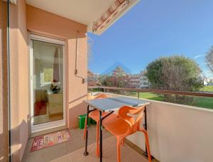 un tavolo e una sedia sul balcone di Chez Camille & Sébastien a Bevaix Altre 3 foto