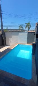 a blue swimming pool on the side of a house at Casa de praia in Praia Grande