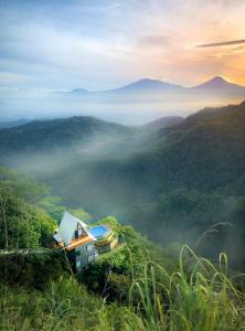 a house on a hill in the middle of a forest at Villane Tumpeng in Giripurno