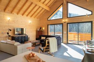 a living room with a vaulted ceiling with large windows at La Tour de l'Enversin in Vaujany
